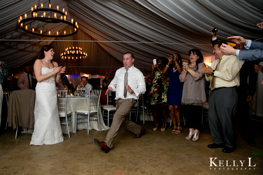 bride and groom dance with guest at reception