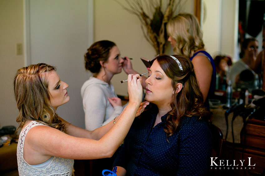 bride getting makeup done for wedding