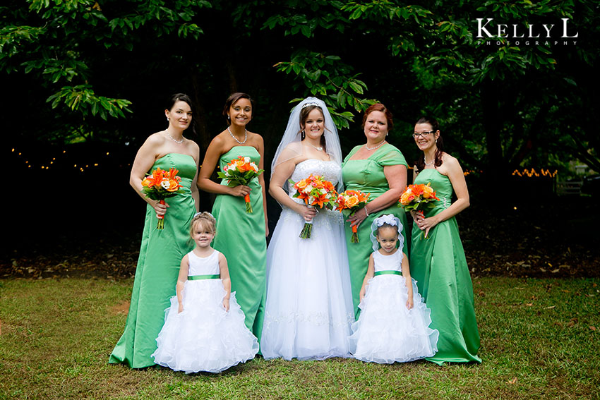 bridesmaids in green dresses with orange flowers