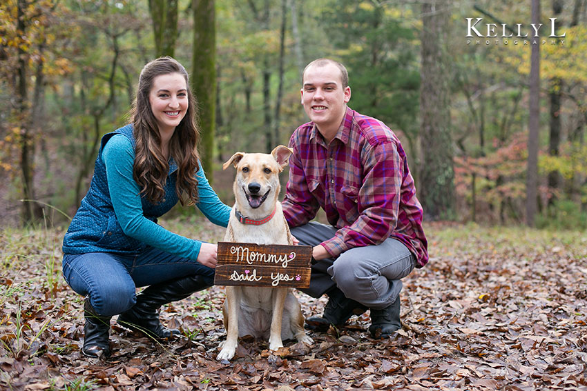 engagement photos with dog holding sign mommy said yes