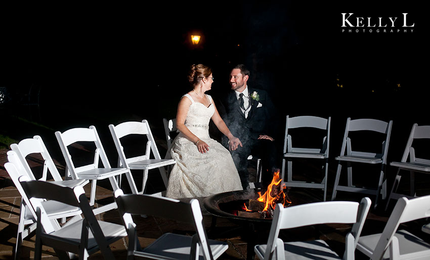 bride and groom sitting by the fire