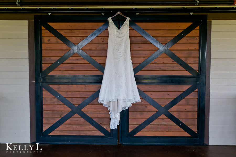 bride's wedding dress hanging on barn doors