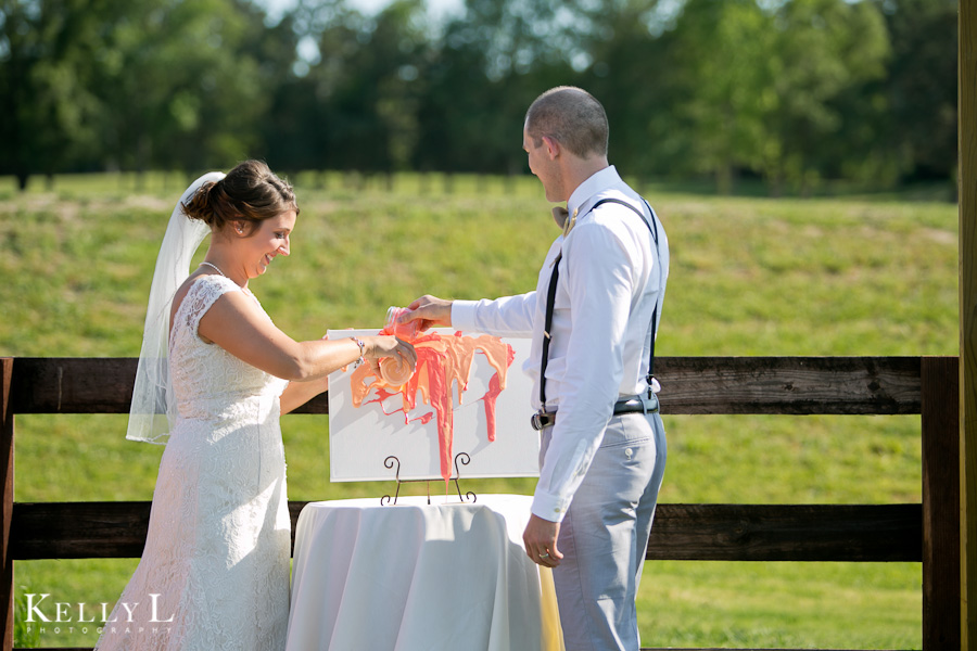 bride and groom create a wedding painting on a blank canvas during ceremony
