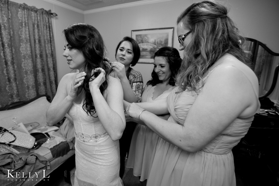 bridesmaids help bride get dressed