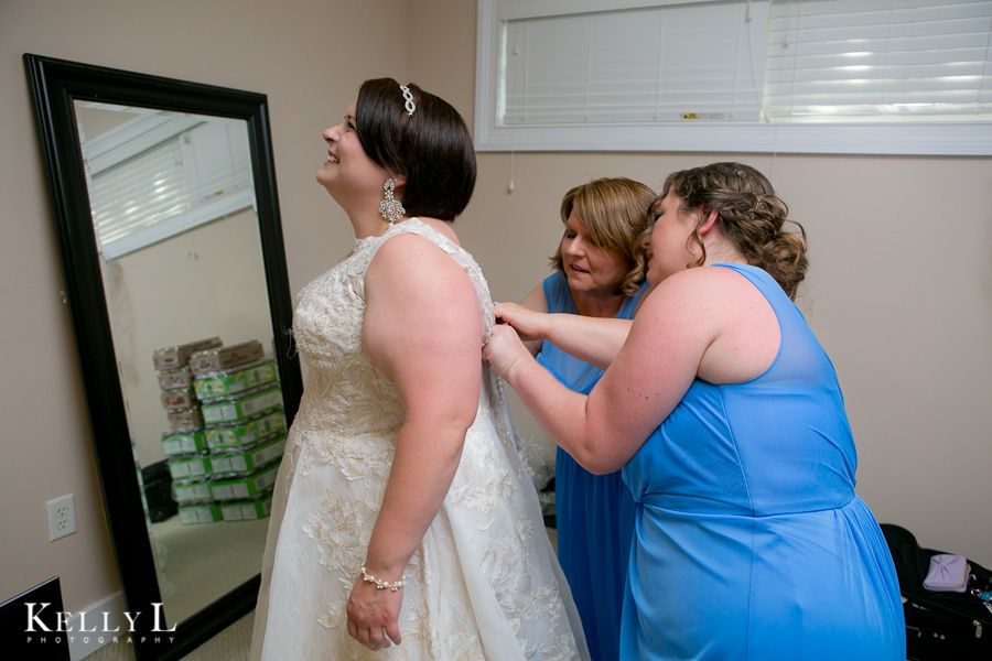 mom and bridesmaid help bride getting ready