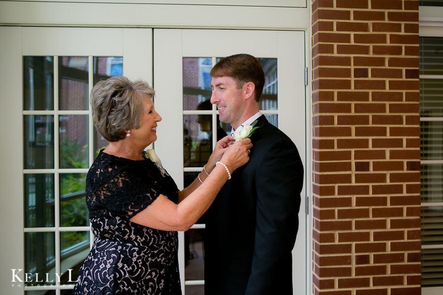mom pins boutonniere on groom 
