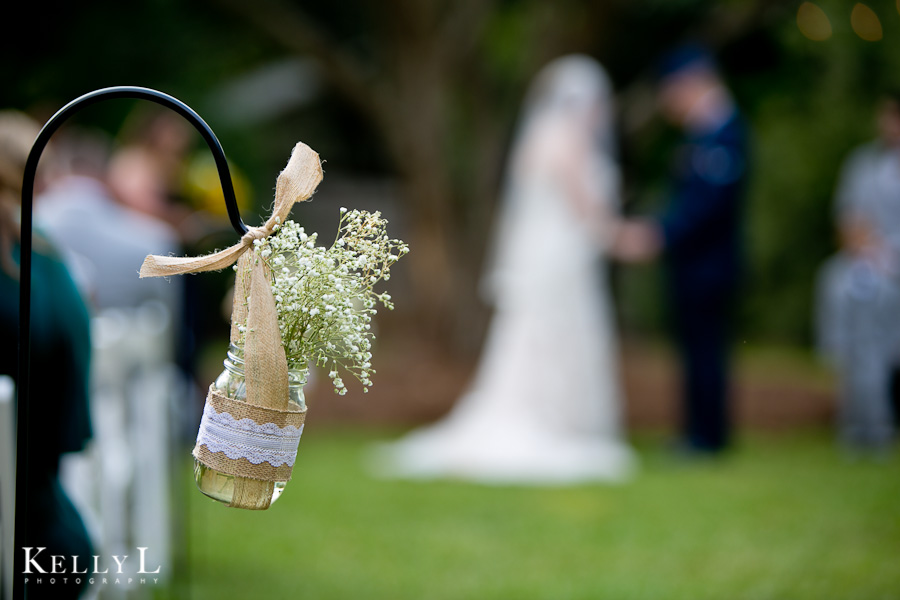 mason jars with baby's breath along wedding ceremony chairs