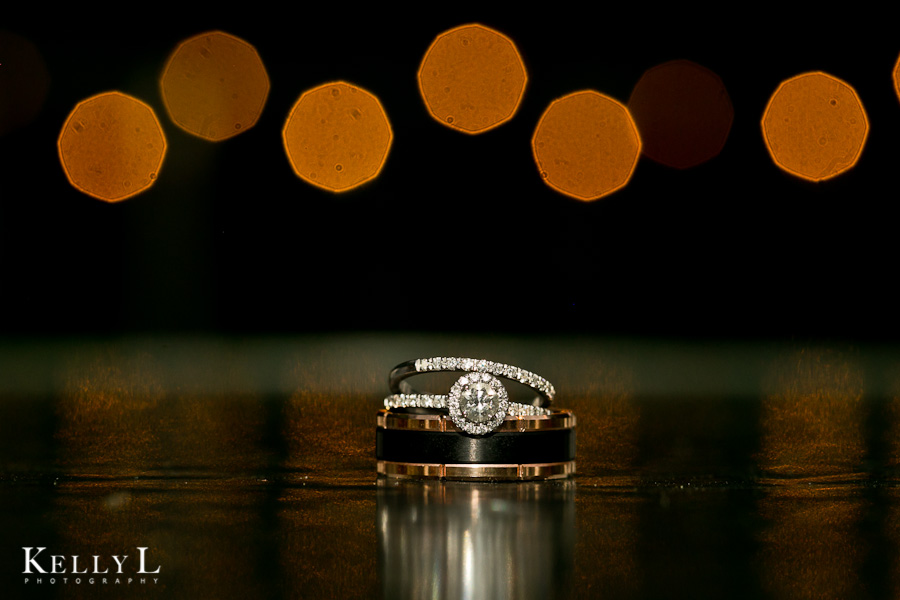 photo of wedding bands and engagement ring at night