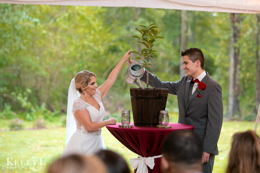 bride and groom plant a tree with soil from their homes